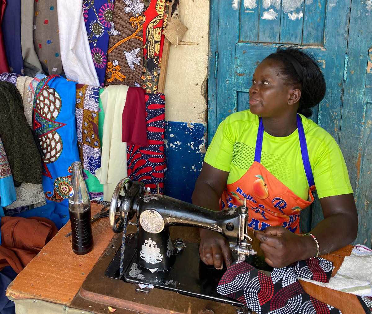 Eine Schneiderin blickt in Richtung Stoffe